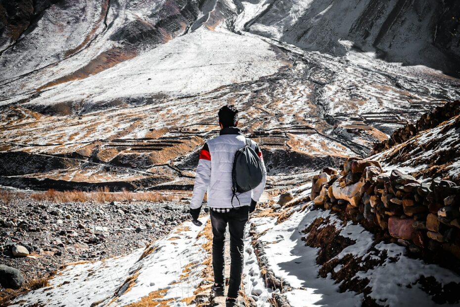 a man walking up a snow covered mountain