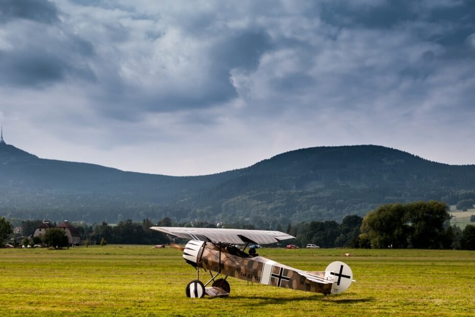 white and black plane on green grass field during daytime